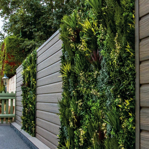 Composite Prime HD Clad Cedar Brown boards installed as modern garden fencing beside vertical greenery, showing a sleek, natural timber-look finish with durable composite performance.