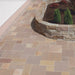 Paveworld Autumn Brown Indian Sandstone patio paving laid in mixed size pattern beside curved stone wall