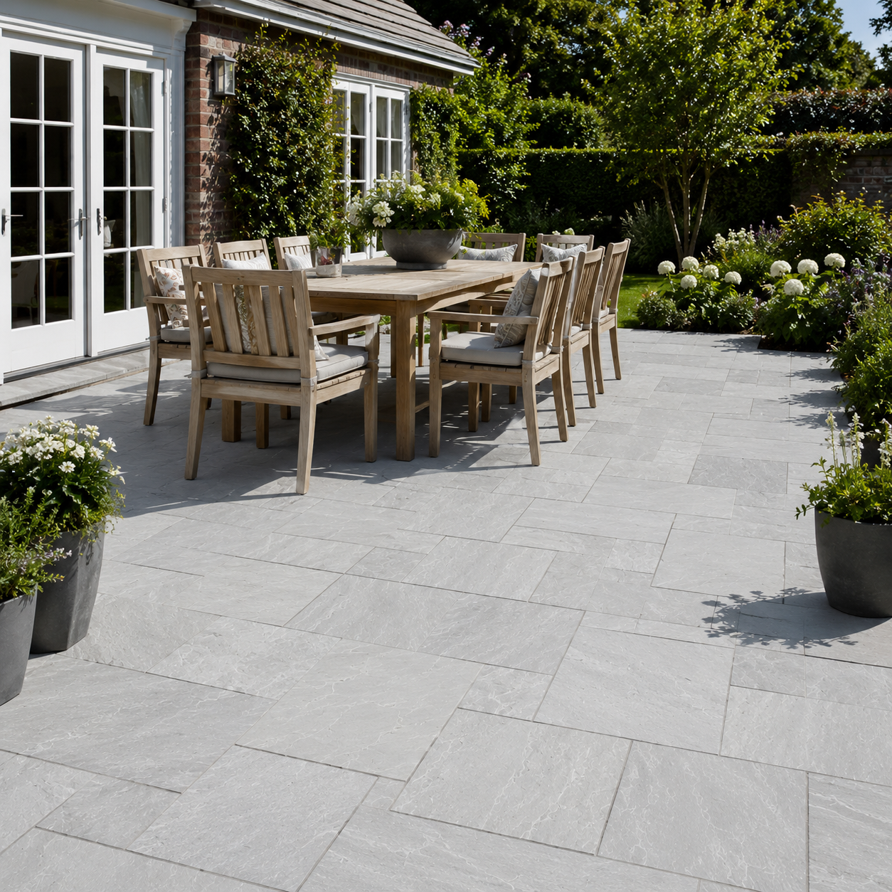 Light Grey Indian sandstone patio with outdoor dining furniture and natural grey paving tones
