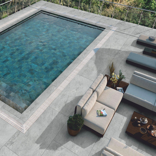 Paveworld Lake Grey porcelain paving installed around modern swimming pool with contemporary outdoor seating area
