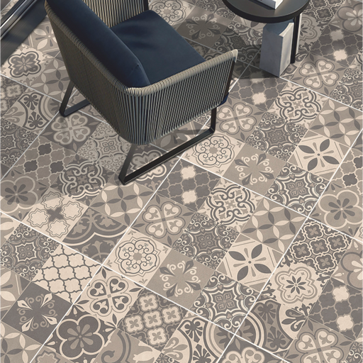 Patterned porcelain paving with mixed grey decorative designs beneath contemporary outdoor seating. 