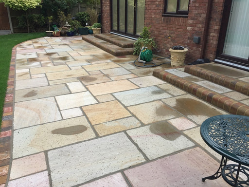Paveworld Rippon Buff sandstone paving installed patio showing natural buff colour variation