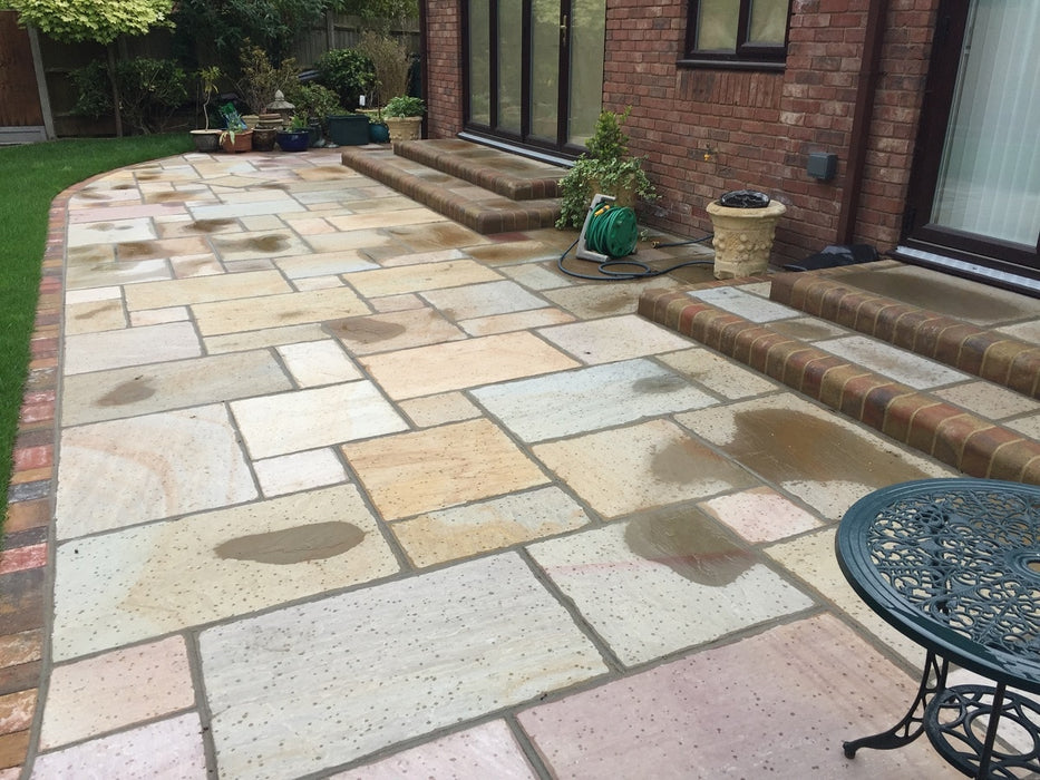 Paveworld Rippon Buff sandstone paving installed patio showing natural buff colour variation
